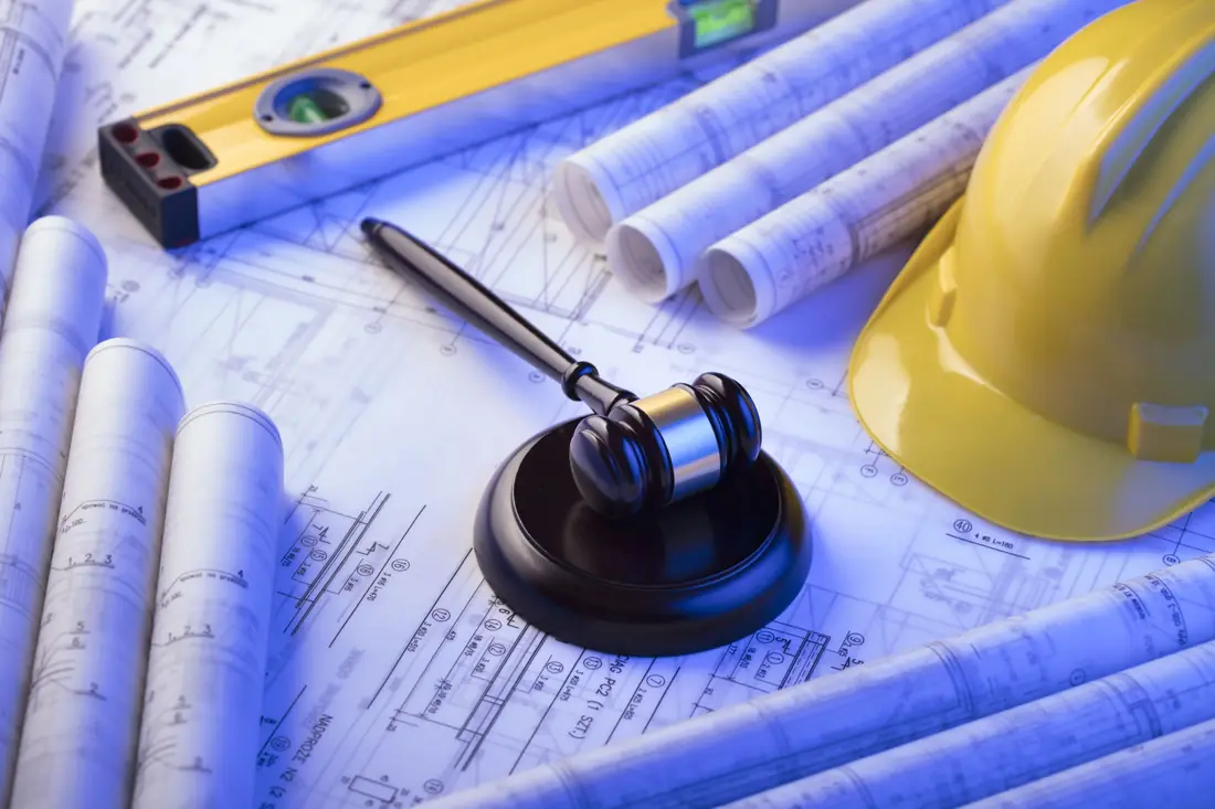 Building plans with a gavel, a spirit level and a hard hat