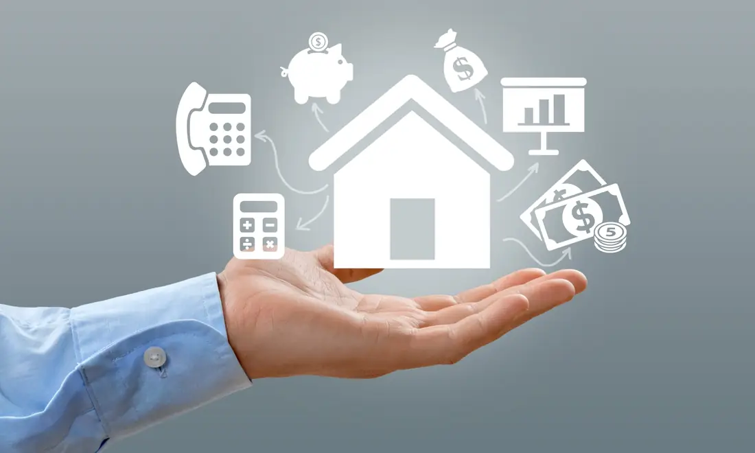 Hand holding a house icon surrounded by finance icons