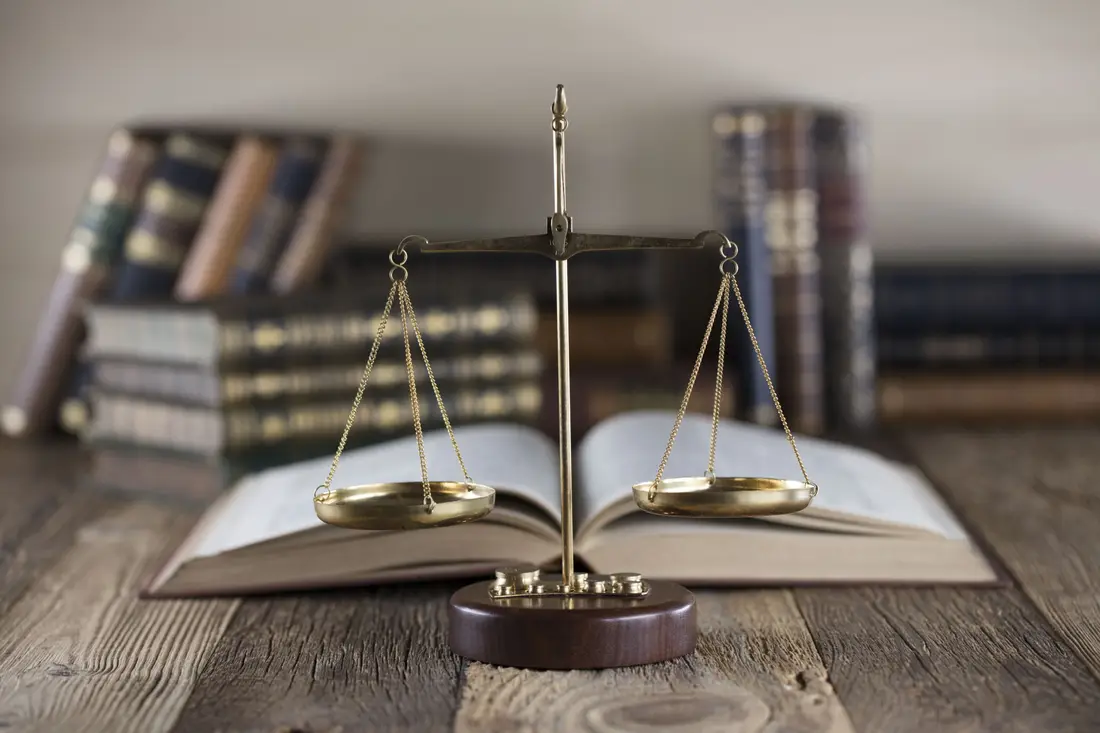 Brass scales in front of open law books